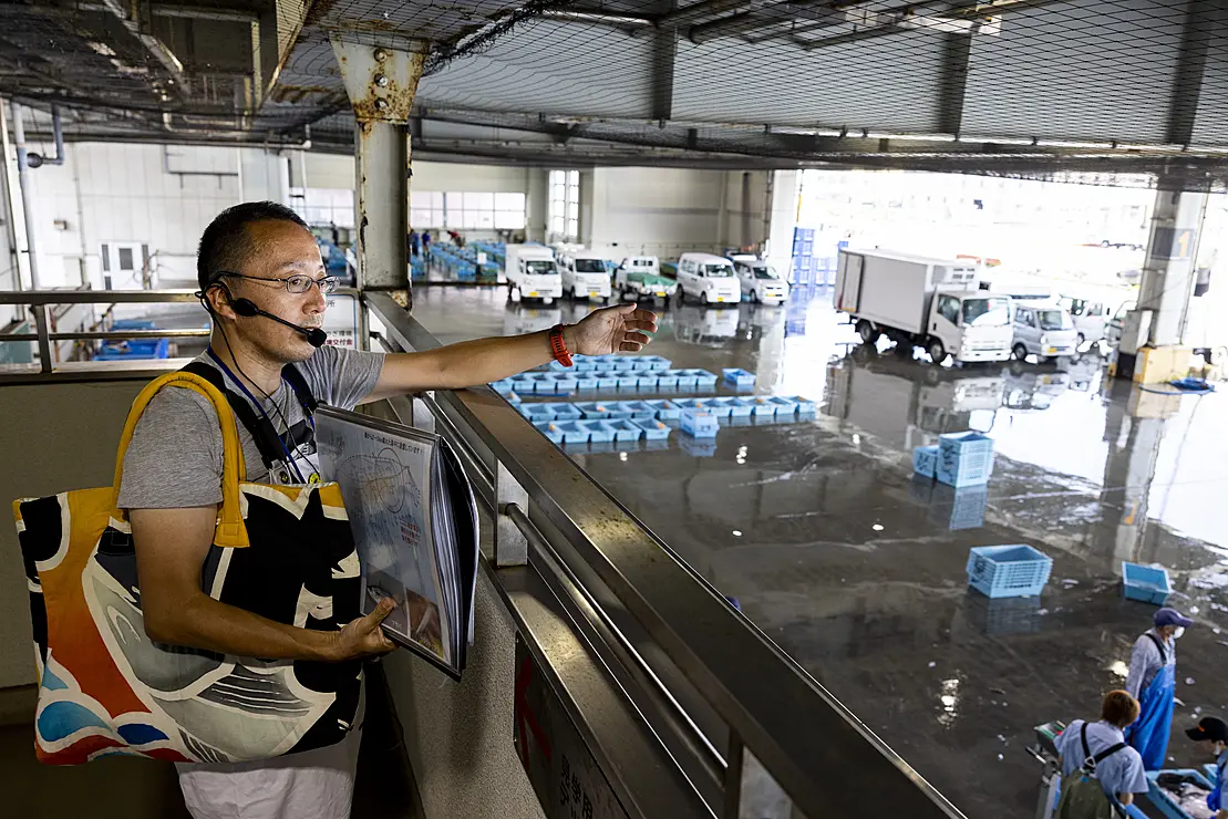 魚市場を案内する男性