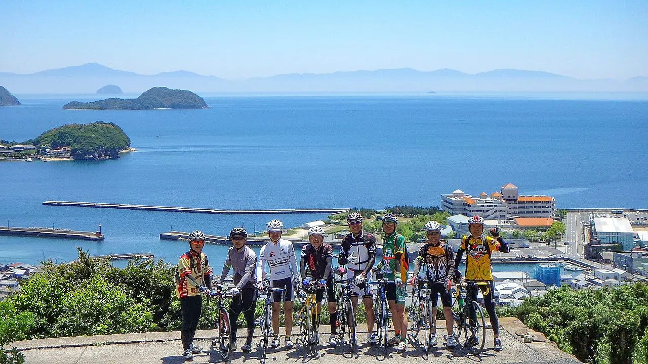 海辺をバックにサイクリングツアーの記念撮影