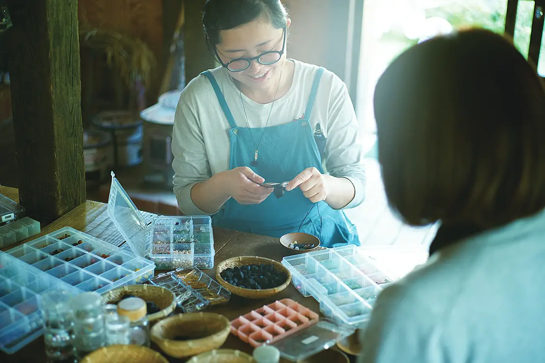 クラフト体験でアクセサリーを作る女性
