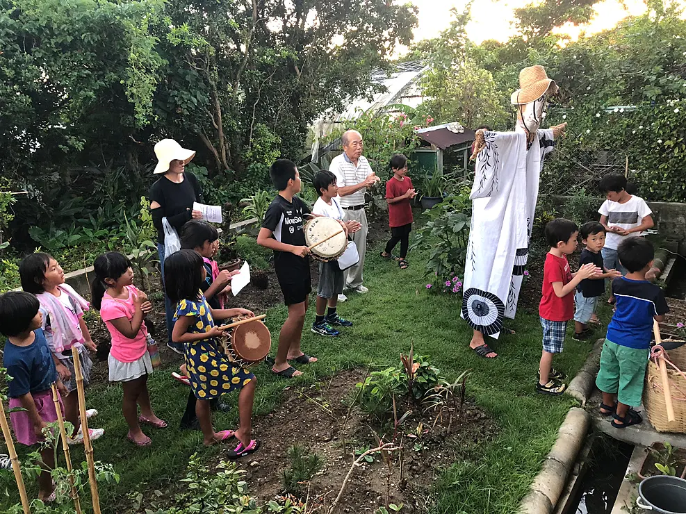 子どもたちがワラ人形（イッサンボー）を担いで、豊作を祈願しながら集落の家々を回っている伝統的な光景