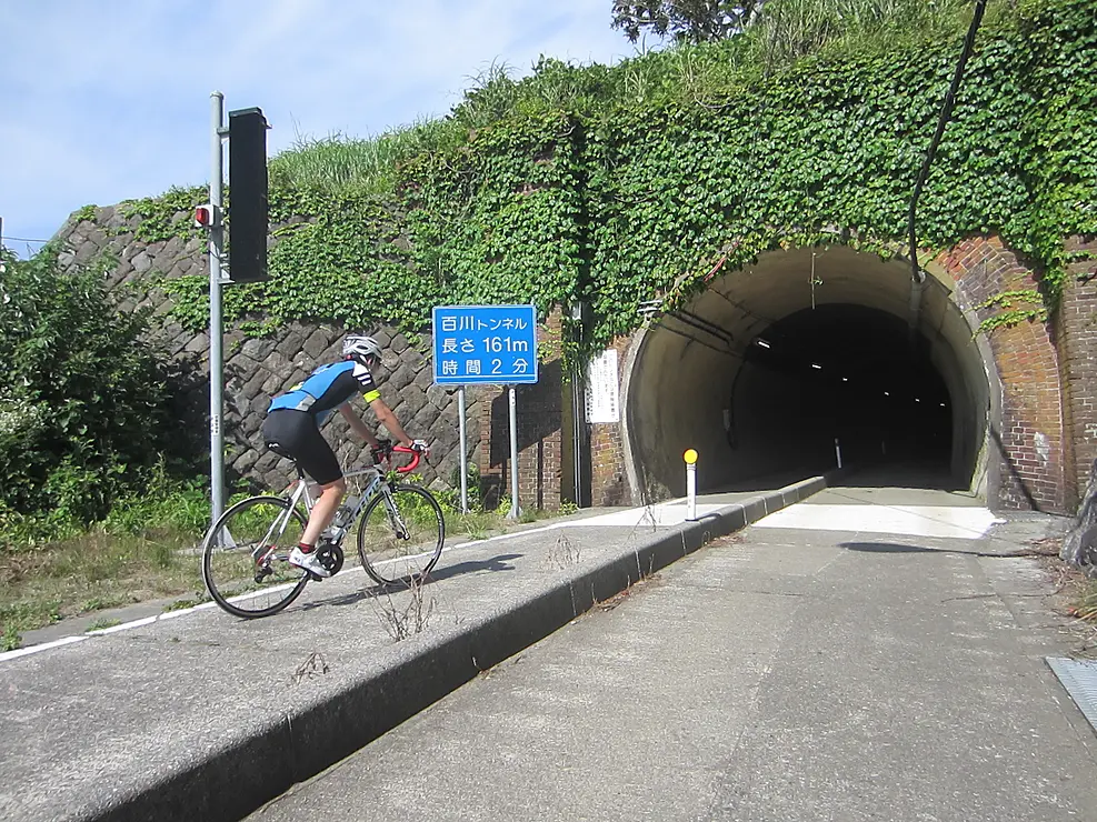 トンネルに向かってサイクリングする男性
