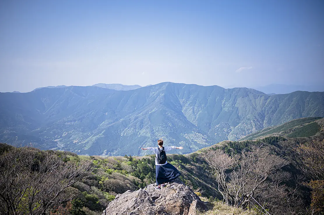 篠山の稜線で両手を広げいる登山者