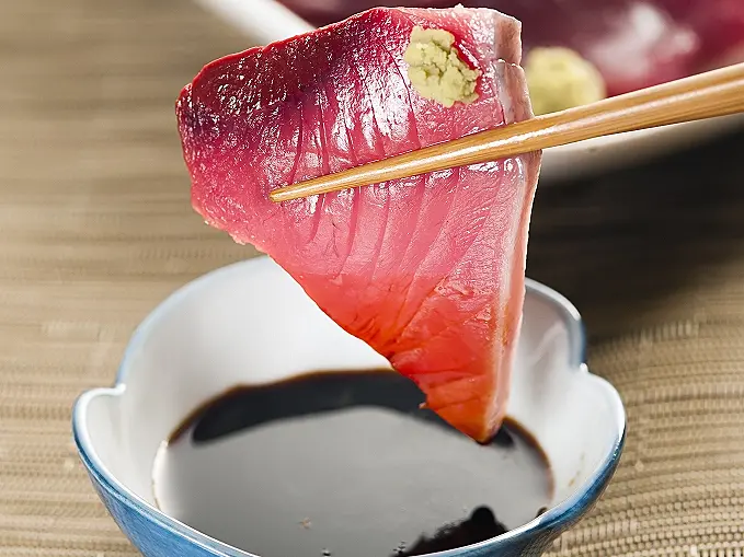 びやびやがつおを刺身醤油をつけていただく