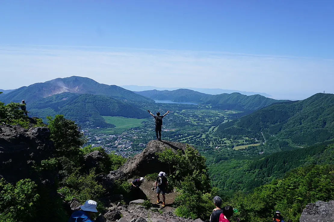 金時山山頂の岩の上で手を広げる人