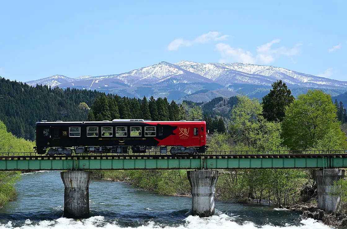 山を背景に橋脚を渡る列車