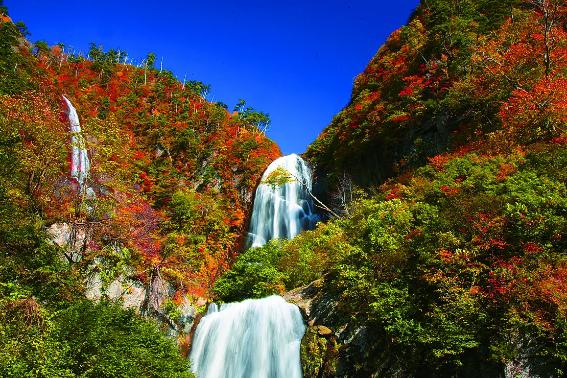 紅葉の中を落ちる二段の滝