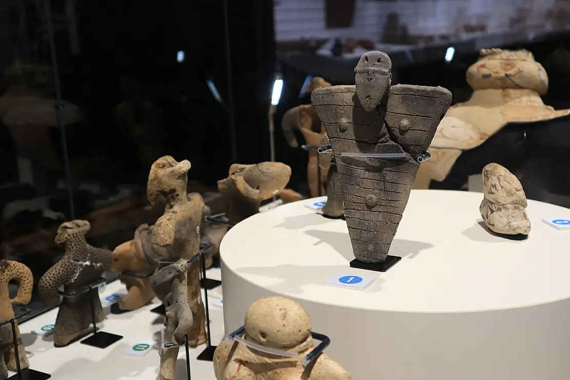 平たい三角形の体の土偶