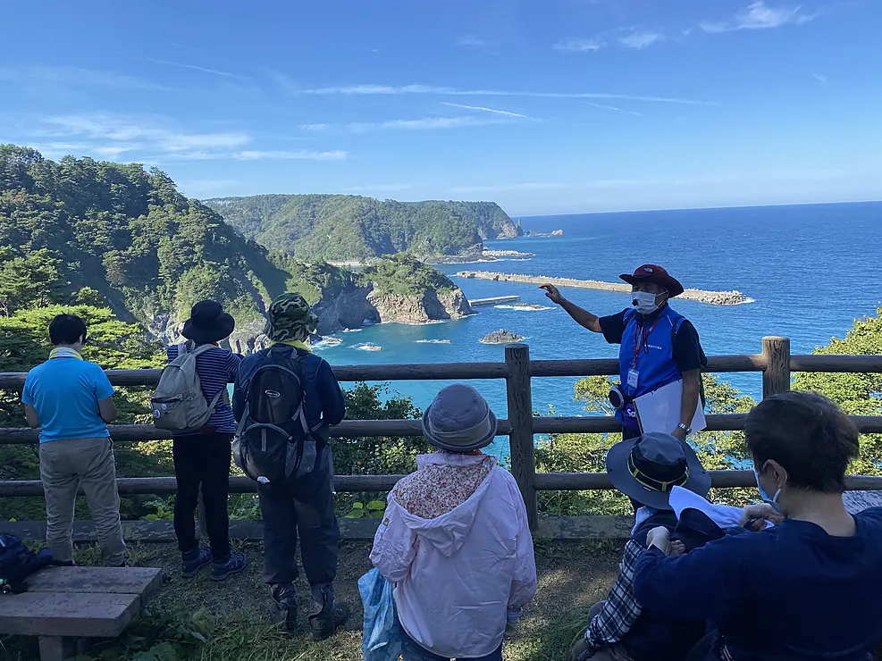 海岸の高台でガイドする人