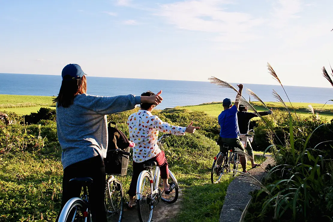海を眺めながら自転車をこぐ人々