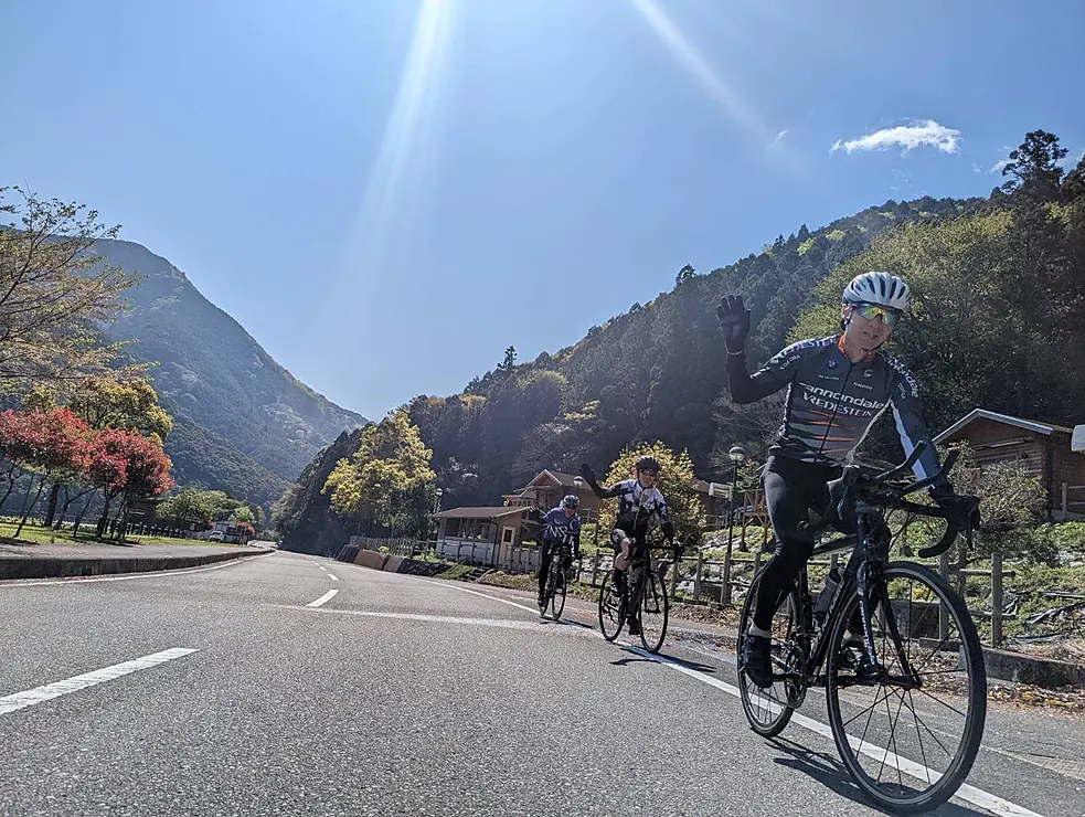 山間の道路をツーリングする人