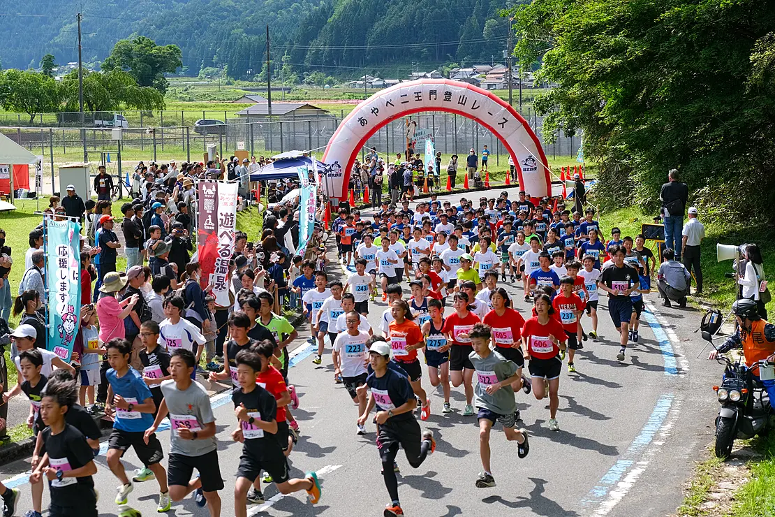 二王門登山レースのスタート地点を勢いよく駆け出す大勢のランナーたち