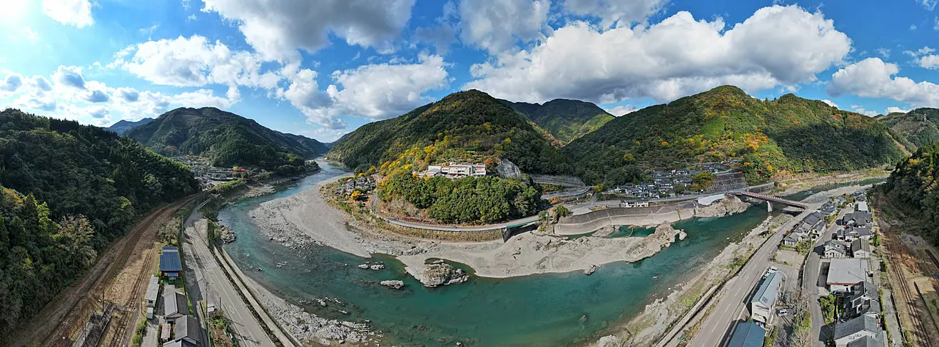 エメラルドグリーンに輝く球磨川の風景。蛇行する川と周囲の緑豊かな山々
