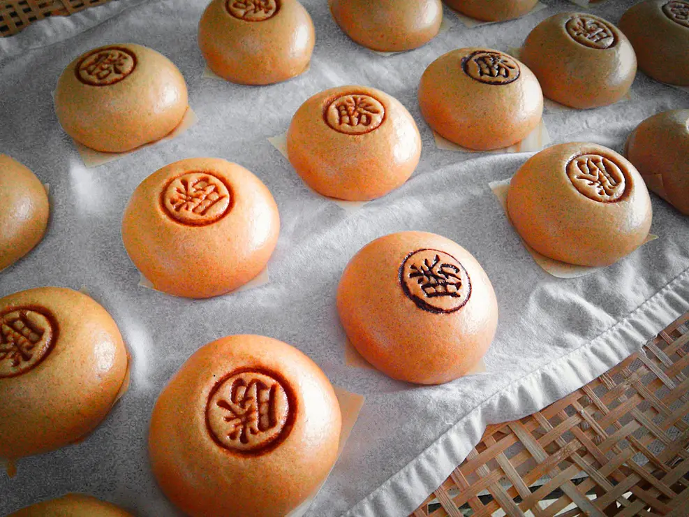 「勝」の焼印が押された丸くて黄金色の饅頭が多数並べられている。