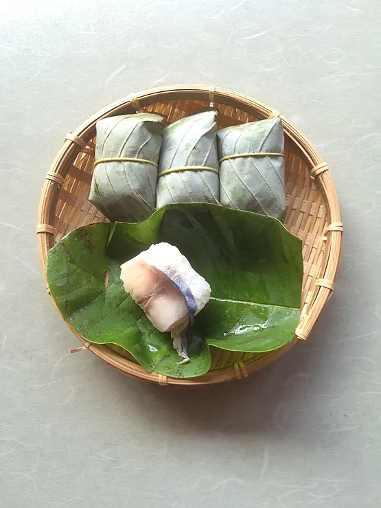 朴の木の葉で包んだ鯖寿司が竹ざるに乗っている