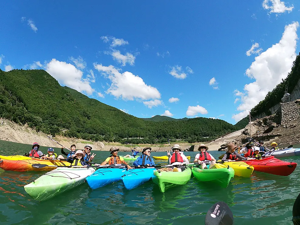 カヤックを並べて記念撮影をする人々