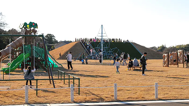 公園内の遊具で遊ぶ家族