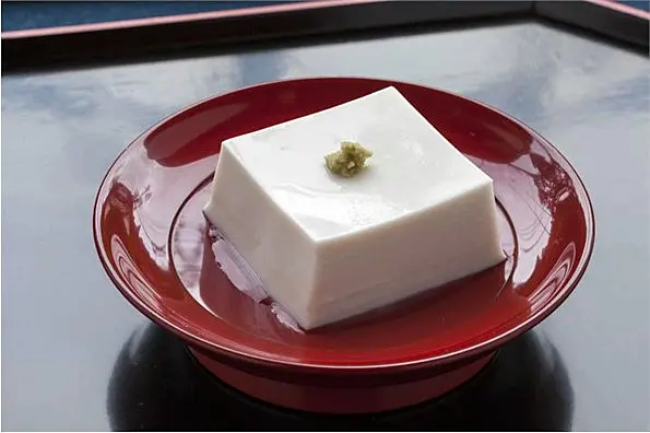 朱塗りのお皿に乗った、ワサビを添えた白いごま豆腐