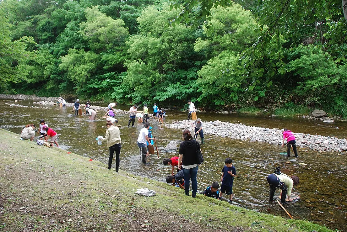 川で砂金堀りを楽しむ家族