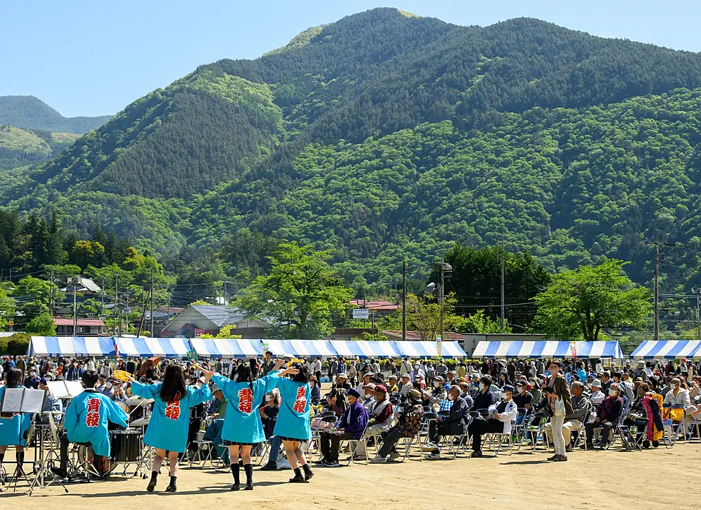 山の麓のグラウンドに集まる人々