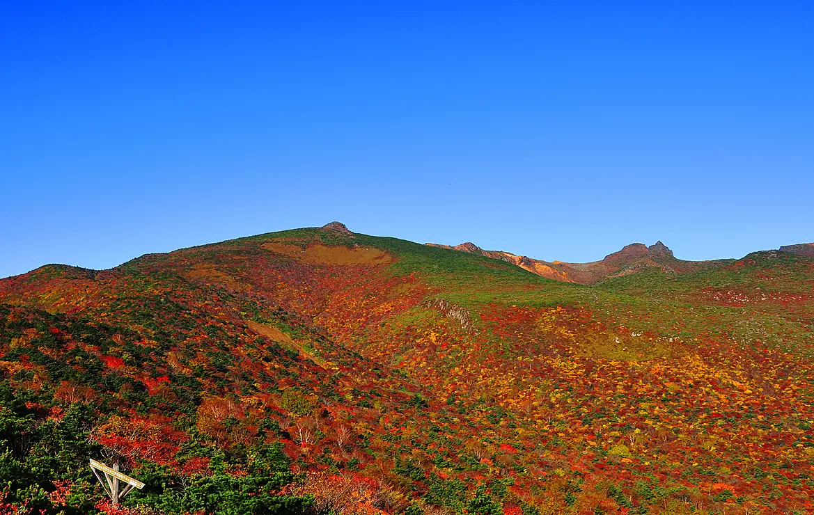 紅葉の山々と雲一つない青空