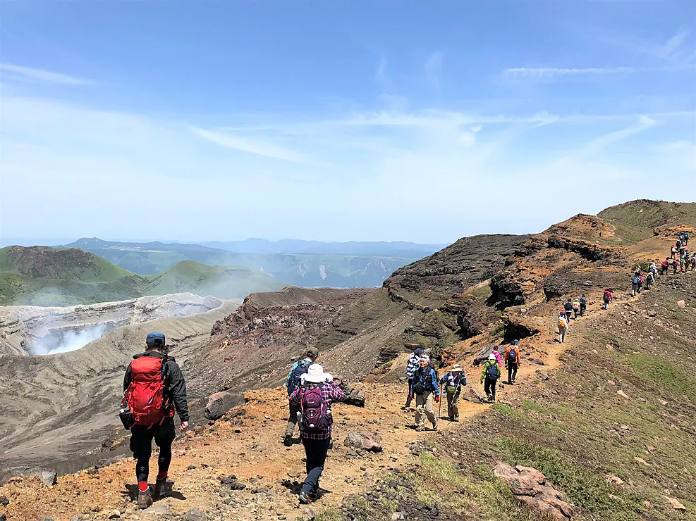阿蘇の山肌をトレッキングする人々の様子