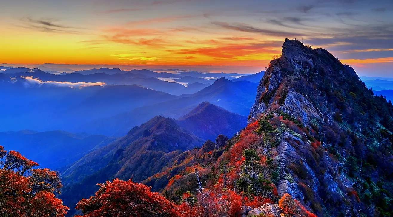 紅葉の石鎚山が朝日に照らされている