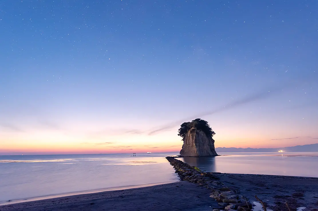 海に大きな岩がそびえ立つ