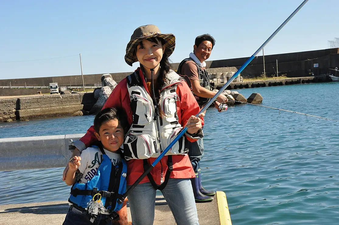 堤防で釣竿を持つ親子