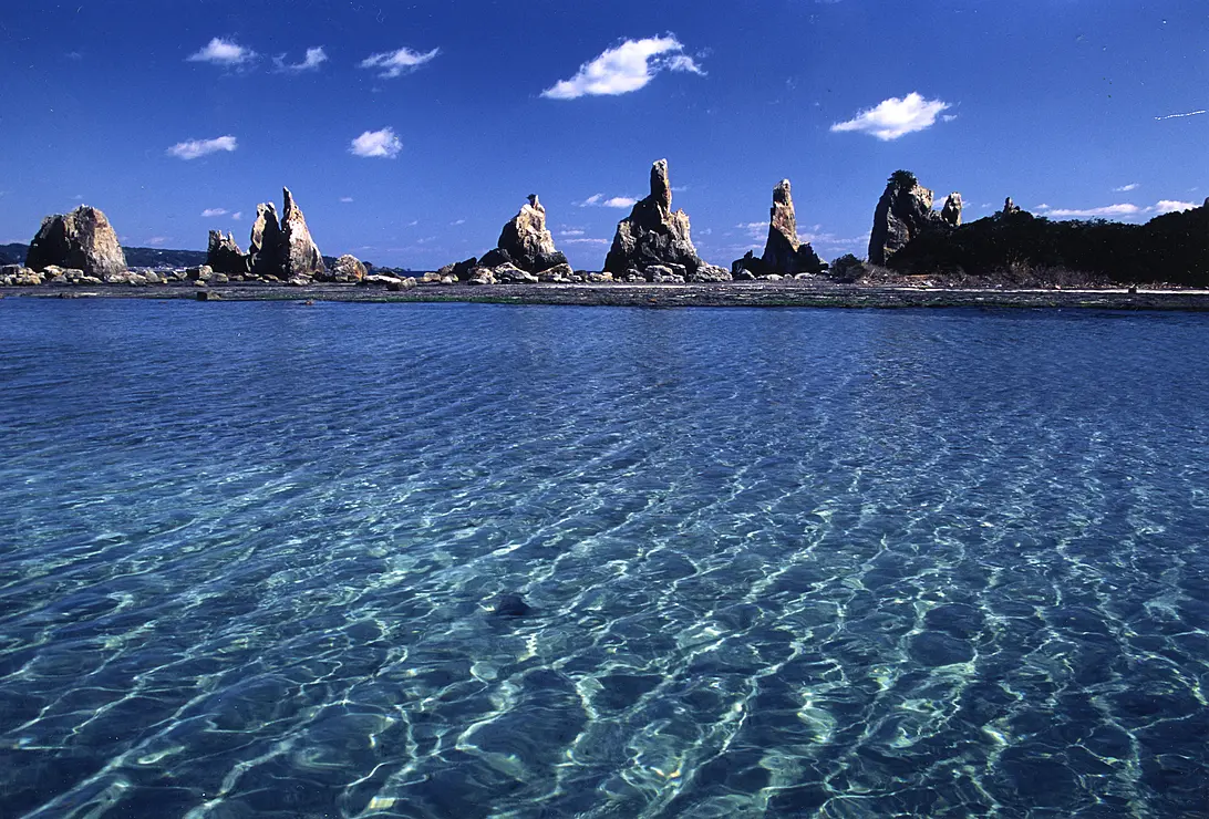 一列に並ぶ岩柱が海面にそり立つ