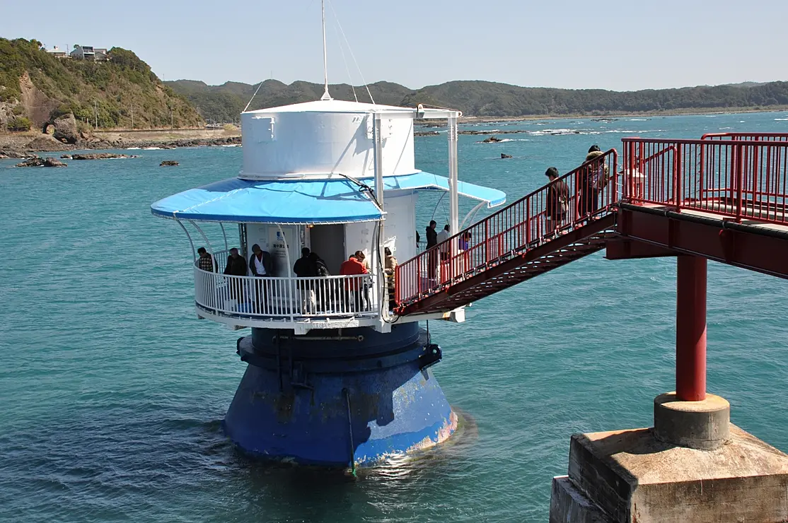 海中から突き出た円筒形の海中展望台の入口に桟橋で渡る人