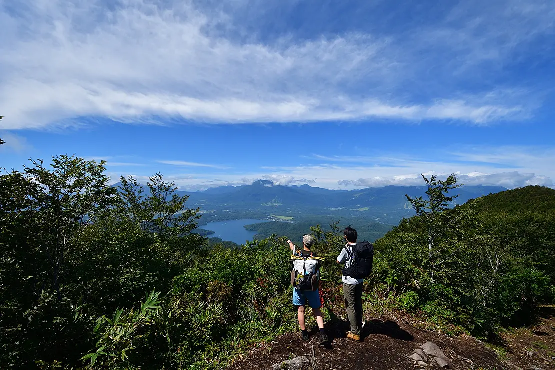 ピークからの眺望を楽しむハイカー