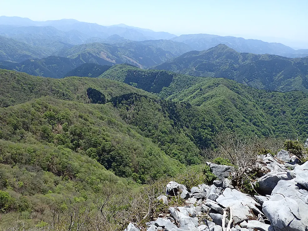 御池岳からの眺望。緑豊かな山々が連なり、青空が広がっている。