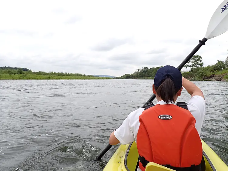 赤いライフジャケットを着た人がパドリングする様子