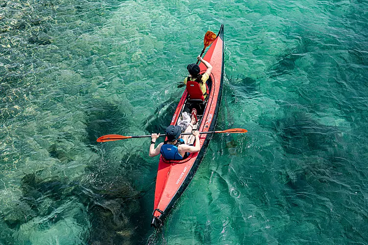 須ノ川公園に面する須ノ川海岸の透明な海面に、2人乗りの赤いカヤックが浮かんでいる
