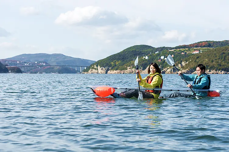 タンデムカヤックを漕ぐ女性と男性