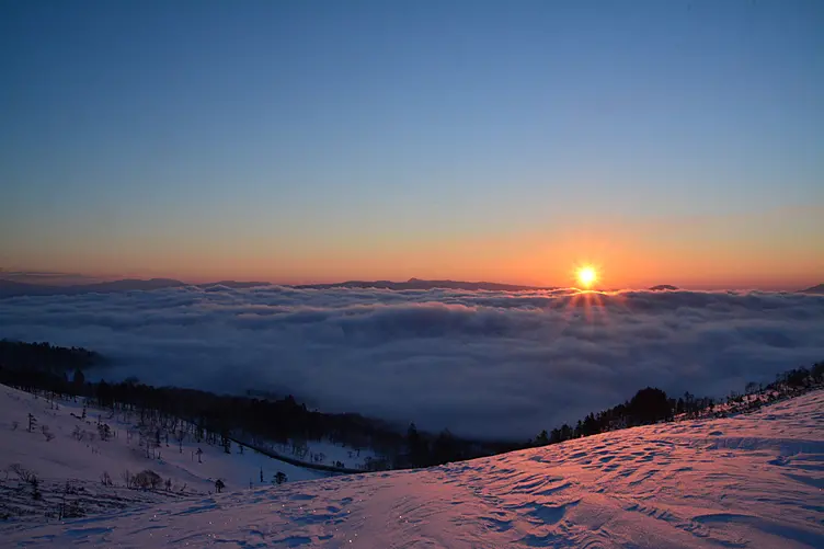 雪景色登るご来光と雲海
