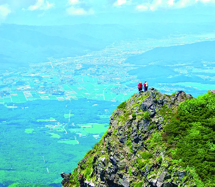 岩壁の上に建つ登山者