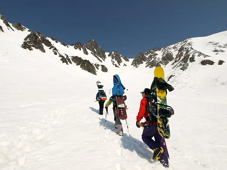 雪が積もった千畳敷カールに登るスノーボーダー