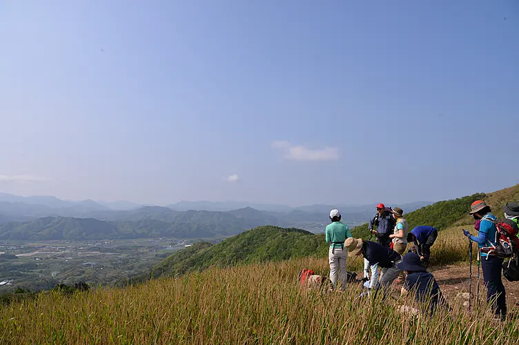 右手前に蒜山を登山するグループと奥に高原の風景