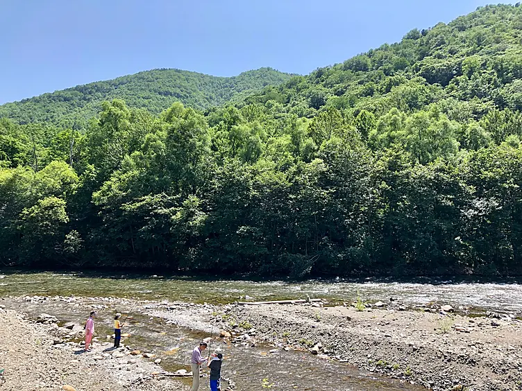 浅い川で遊ぶ人々