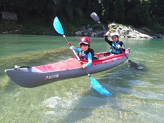川で二人乗りカヤックに乗る人