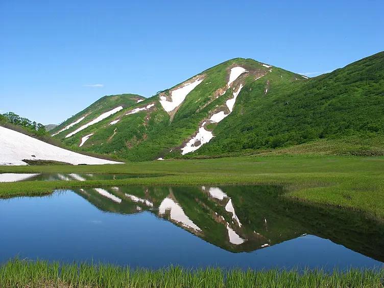 静かな湖面と残雪の山