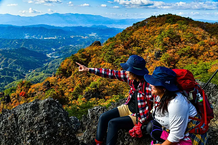 紅葉の山を登る女性二人