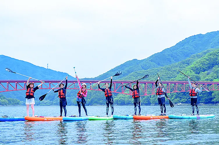 SUPに乗っている人が湖で並んでいる様子