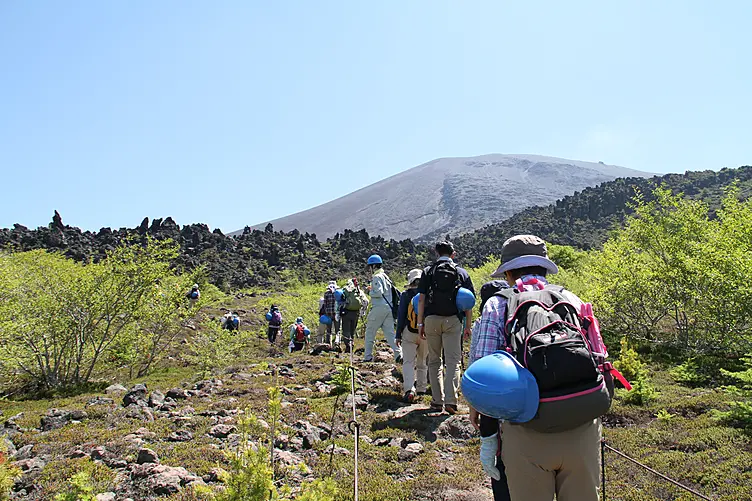火山の山に登る人々