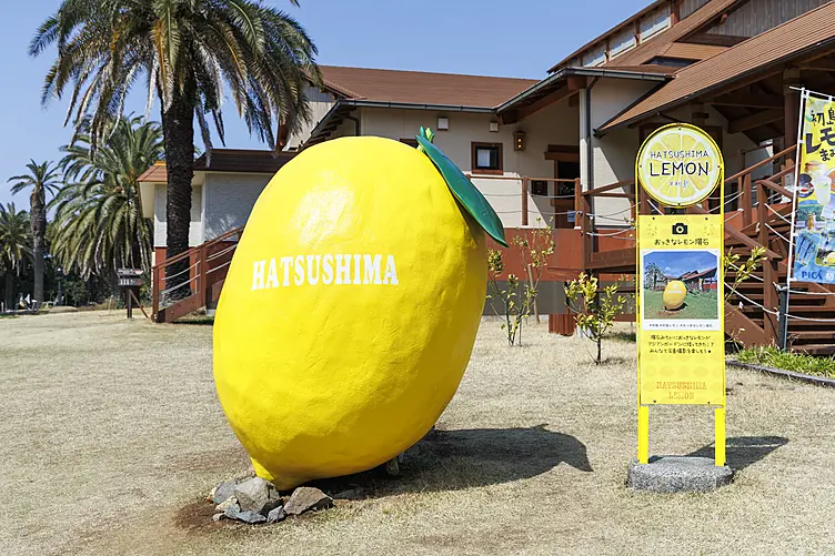 レモンのモニュメントと黄色いバス停