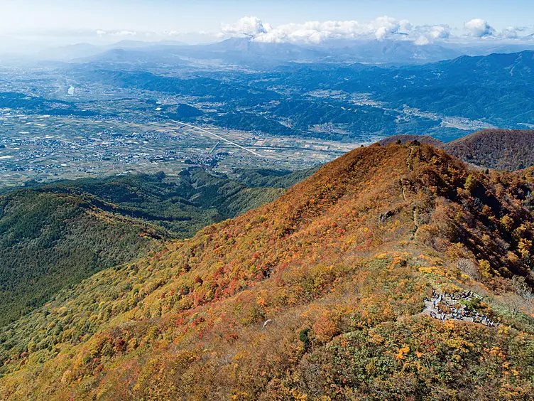紅葉の山と裾野に広がる市街地
