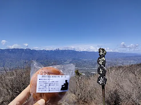 山頂であんぱんを掲げている
