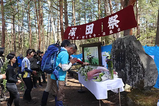 石碑の前で献花する人